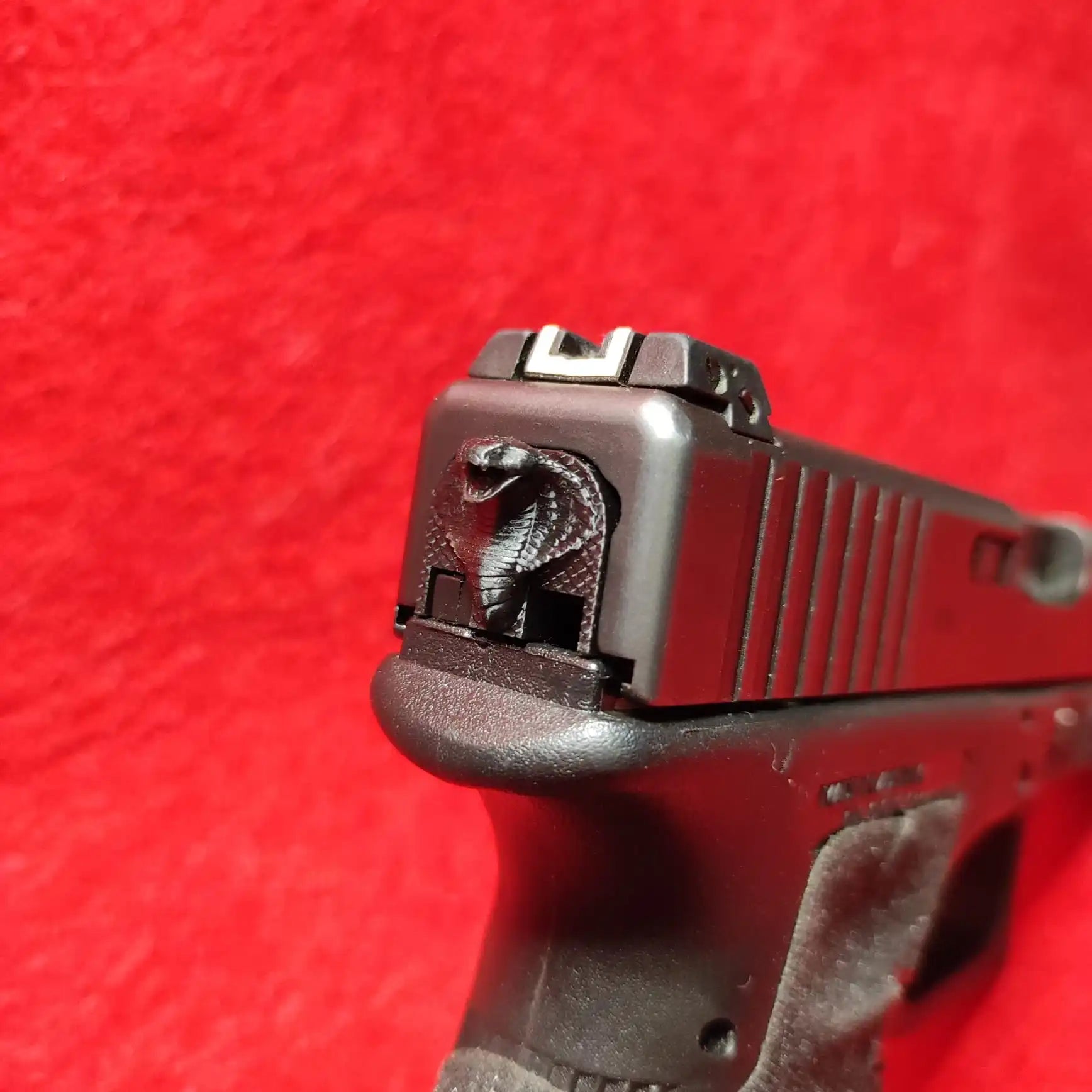 Black handgun with cobra slide cover plate.