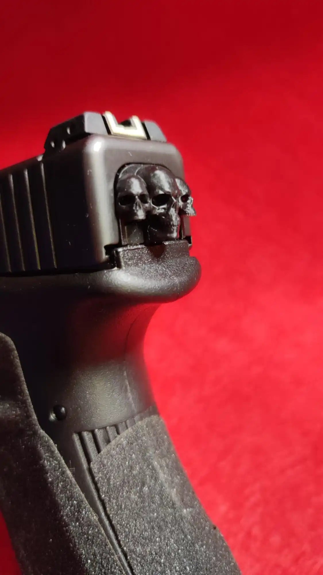 Black handgun with skull detail.